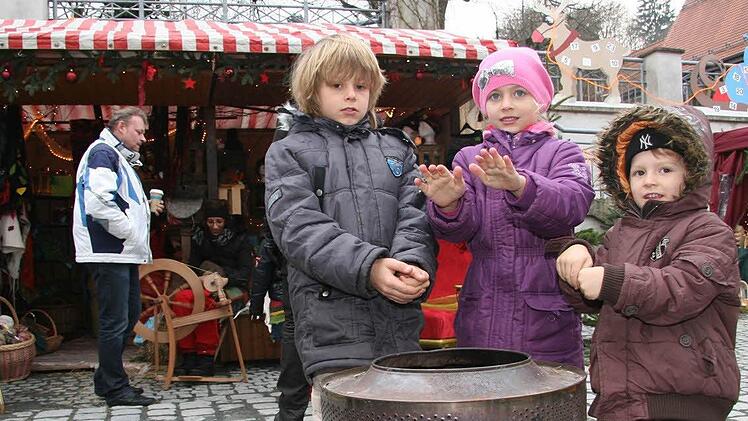 Ferris, Fanny und  Finian Eichner wärmen sich  am Feuer.
