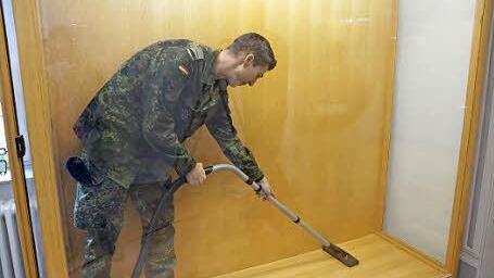 Kein Exponat: Ein Soldat saugt einen Schaukasten aus.