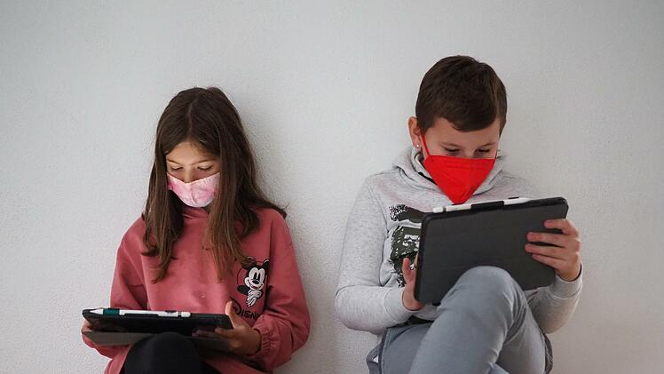In der Aula informieren sich Lilien und Leonardo für den Musikunterricht mit ihren Tablets über das Ballett "Der Nussknacker". Beide besuchen die vierte Klasse.
