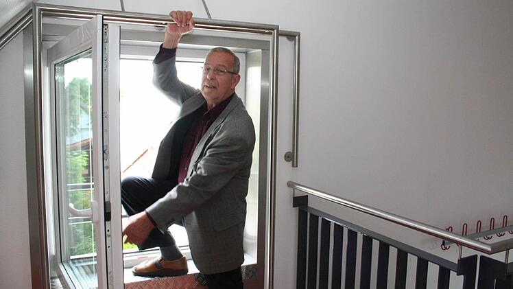 An einem Fenster im Dachgeschoss können die Aktiven die Selbstrettung mit dem Seil üben. Vorsitzender Georg Heyd demonstriert, wie das geht