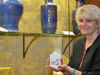 Eine Teebüchse der Würzburger Porzellanmanufaktur ist nur vorübergehend auf Schloss Aschach zu sehen. Museumsleiterin Annette Späth zeigt sich erfreut über die Aktion "Kunst geht fremd".  Foto: Björn Hein
