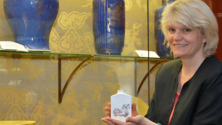 Eine Teebüchse der Würzburger Porzellanmanufaktur ist nur vorübergehend auf Schloss Aschach zu sehen. Museumsleiterin Annette Späth zeigt sich erfreut über die Aktion "Kunst geht fremd".  Foto: Björn Hein