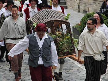 Eine Housnkuh durch Kronach zu tragen, ist selbst zu viert ein harter Job. Foto: Marco Meißner
