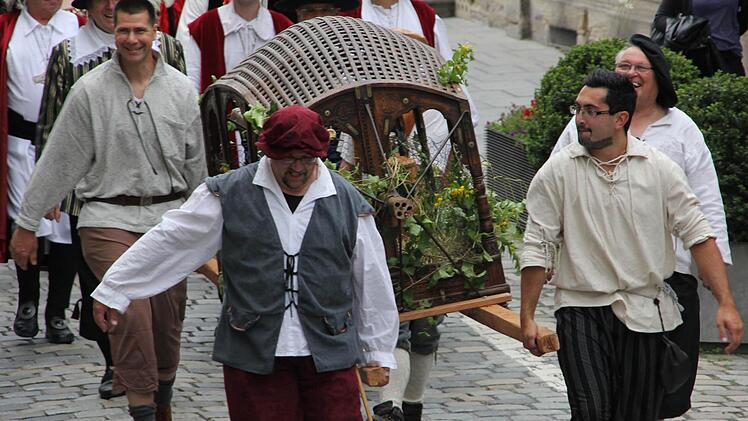 Eine Housnkuh durch Kronach zu tragen, ist selbst zu viert ein harter Job. Foto: Marco Meißner