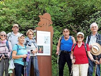 Bei der Wanderung gab es Zeitfenster in die Vergangenheit. Ein Teil der Wandergruppe vor einem Hinweisschild auf die Sagengestalt des Rh&ouml;n-Paulus. Foto: Hans-J&uuml;rgen Neumann