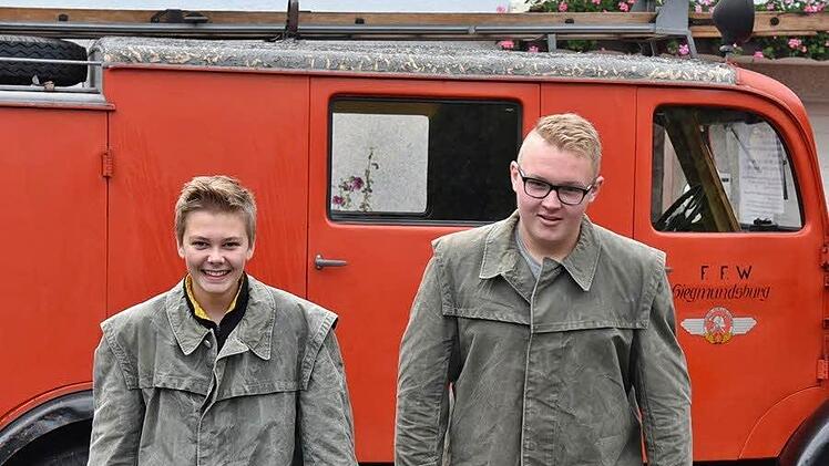 Yannik Wolf und Bastian Fischer von der Jugendfeuerwehr Mittelberg haben sich alte Löschanzüge übergestreift. Foto: Gabi Arnold