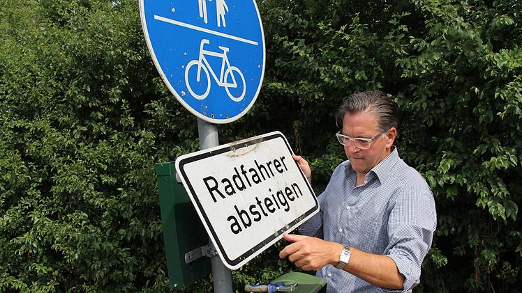 Bürgermeister Karsten Fischkal schraubte persönlich das Schild "Radfahrer absteigen" ab.  Foto: Christian Bauriedel