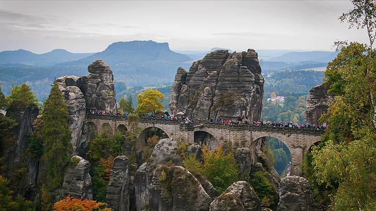 Die Basteibrücke im Nationalpark Sächsische Schweiz bei Dresden, Deutschland, an einem nebligen Herbsttag. The Bastei stone bridge in the Saxon Switzerland National Park near Dresden, Germany on a foggy autumn day.