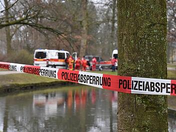 Die Rettungskräfte des DLRG stehen an einem Kanal im Hofgarten. Passanten hatten in dem Kanal einen Toten entdeckt. Die Kripo ermittelte, dass der Mann ertrunken ist. Foto: Rudi Ziegler/dpa