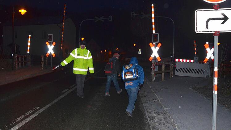 Anstatt auf dem Gehweg die Gleise überqueren zu können, müssen die Schulkinder auf der Straße am Trebgaster Bahnübergang vorbei geleitet werden, weil der fertige Fußweg wegen fehlender Begrenzungslinien seit November gesperrt ist. Foto: Dieter Hübner