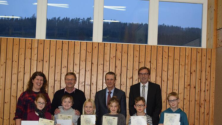 Hinten: Rektorin Katharina Schöberl, Bürgermeister Wilhelm Friedrich, Schulamtsdirektor Rupert Kestler und VR Kreisverbandsmitglied Robert Kennaugh. Die Gewinner (v.l.): Emma Hofmann, Sinnberg Grundschule Bad Kissingen Platz 1; Nick Beitinger, Grundschule Wildflecken Platz 1; Jade Klüh, Volksschule Motten Platz 3; Anne Reh, Johannes Petri Volksschule Langendorf Platz 2; Kilian Benkert, Einhard Volksschule Euerdorf Platz 3; Leon Greß, Henneberg Grundschule Garitz Platz 2.
