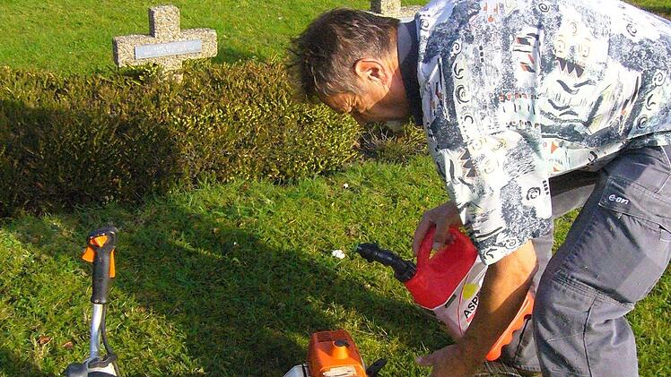 Günter Behr füllt Benzin nach für seinen Grasschneider. Foto: Paul Ziegler