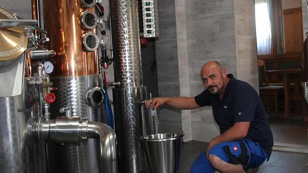 Florian Leicht nimmt eine Alkohol-Stichprobe in seiner Brennerei. Die Teile der Anlage, in denen der Brennvorgang stattfindet, sind aus Kupfer - das sei wichtig für den Geschmack, erklärt der Fachmann. Fotos: Sven Dörr