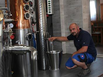 Florian Leicht nimmt eine Alkohol-Stichprobe in seiner Brennerei. Die Teile der Anlage, in denen der Brennvorgang stattfindet, sind aus Kupfer - das sei wichtig für den Geschmack, erklärt der Fachmann. Fotos: Sven Dörr