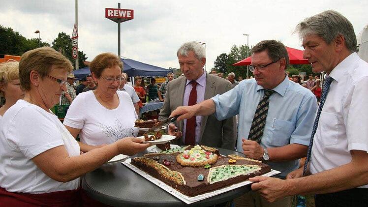 Der Kreisverkehrskuchen wird angeschnitten und Staatssekretär Gerhard Eck verteilt. Foto: Werner Baier