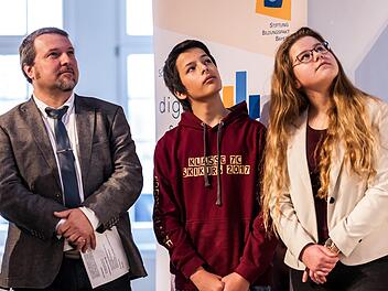 Schulleiter Philipp Arnold und die Achtklässler Julian Jarski und  Carolin Jakob (von links) präsentierten in München Projekte der digitalen Modellschule in Ebern. privat