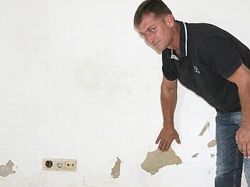 Ein unansehnlicher Anblick: Putz bröckelt im Erdgeschoss des Mainecker Gemeindehauses von der Wand, die mit schwarzen Schimmelflecken übersät ist. Zweiter Bürgermeister Georg Deuerling machte sich ein Bild von den Schäden.