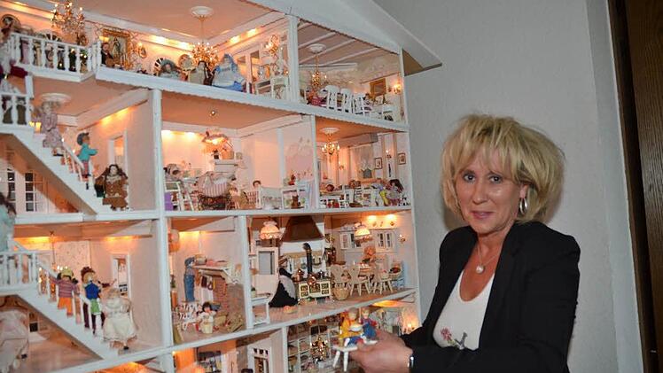Ruth Hofmann vor ihrem liebevoll kreierten einzigartigen Puppenhaus. Sie hält ihre Lieblingspüppchen, Johannes und Tanja, in der Hand. Foto: K.-H. Hofmann