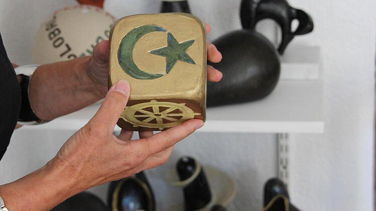 Vorne das Symbol des Islams, unten das Rad des Buddhismus, dazu die Zeichen des Christentums, der Juden, der Hindus und Ying und Yang. Foto: Katja Kölbl