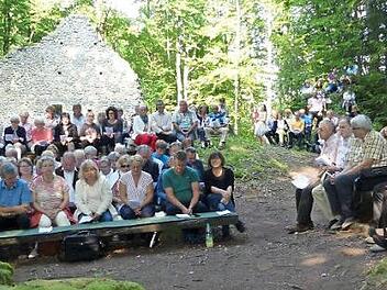 Auf Bänken, Stühlen, dem Boden und Felsen fanden die Besucher Platz.  Foto: Paul Pöhlmann
