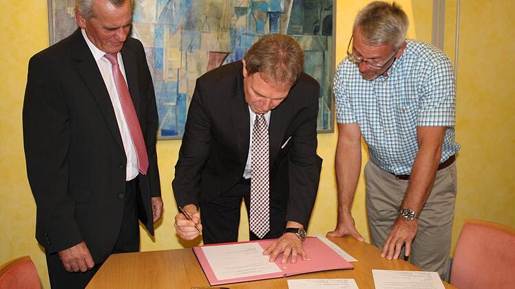 Der neu gewählte Landrat, Klaus Löffler (Mitte), hat noch am Wahlabend die Erklärung zur Annahme der Wahl unterschrieben. Die Amtszeit beginnt am 21. Dezember. Links im Bild der derzeitige Landrat Oswald Marr, rechts Wahlleiter Michael Schaller vom Landratsamt.  Foto: Bernd Graf