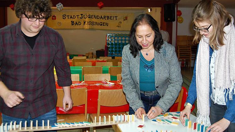 Der künftige Jukuz-Leiter Philipp Pfülb mit Ana Maria Benevides Werner, der Vorsitzenden des Bad Kissinger Integrationsbeirats, und einer Helferin beim Aufbau der Domino-Bahn.  Foto: Sigismund von Dobschütz
