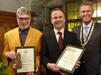 Oberbürgermeister Siegfried Müller überreicht dem Dekanatskantor Carl Friedrich Meyer und dem Regionalkantor Christian Stegmann den Kulturpreis der Stadt Kitzingen.