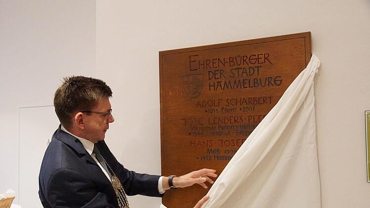 Bürgermeister Armin Warmuth enthüllt eine der Tafeln mit den Namen der Ehrenbürger. Jetzt ist auch Hans-Josef Fell  darauf vermerkt. Foto: Arkadius Guzy