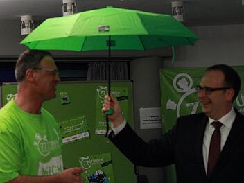 Pfarrer Georg Birkel übergab Landrat Christian Meißner einen grünen Regenschirm als Zeichen der Schirmherrschaft über die 72-Stunden-Aktion des BDKJ im Landkreis Lichtenfels. Foto: Manuel Stark