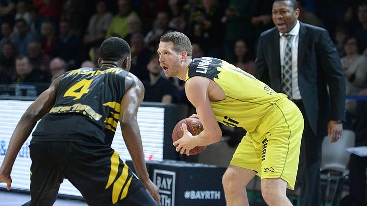 Nate Linhart wird vom Tübinger Julian Washburn geblockt. Rechts Gästetrainer Tyron McCoy. Foto: Peter Mularczyk