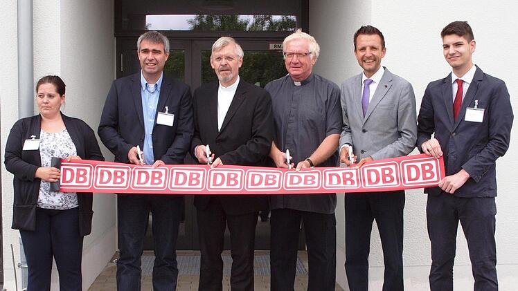 Der DB-Netz-Repräsentant Sirko Kellner, der katholische Pfarrer Roland Neher und der evangelische Pfarrer Ralph-Peter Zettler sowie der Bürgermeister Andreas Hügerich (von links) durchschneiden vor dem offiziellen Einlass in das neue Gebäude das von zwei DB-Netz-Mitarbeitern gehaltene Band. Foto: Alfred Thieret
