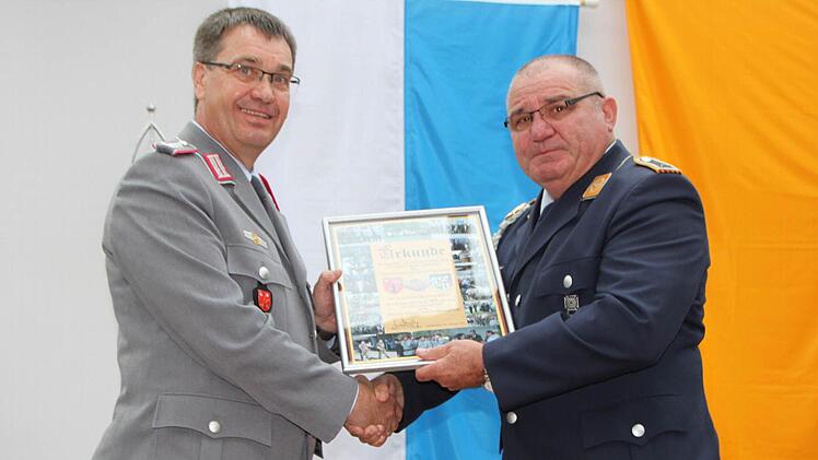Oberst Jürgen Steinberger Ulinks) überreicht eine Urkunde an Vorsitzenden Karl Veit. Foto: Ulrike Müller