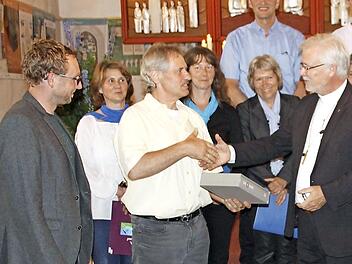 Übergabe der Altarbibel von Regionalbischof Nitsche (r.) an den Bieberbacher Mesner und Kirchenvorstand Reiner Hofmann Foto: R. Löwisch