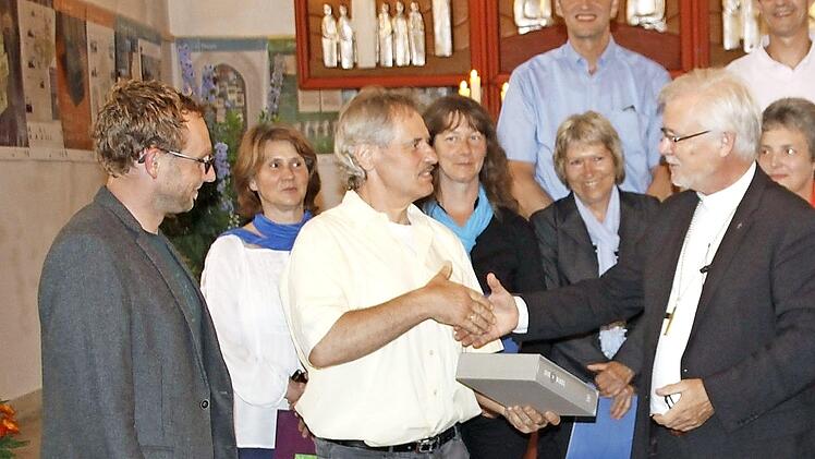 Übergabe der Altarbibel von Regionalbischof Nitsche (r.) an den Bieberbacher Mesner und Kirchenvorstand Reiner Hofmann Foto: R. Löwisch
