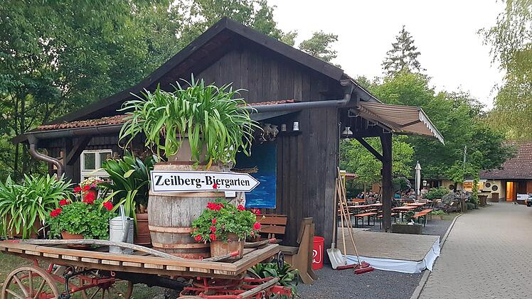 Ein Leiterwagen begrüßt die Gäste, die Holzhütte beherbergt den Flohmarkt und etwas weiter hinten erinnert eine Lore an den Basaltabbau.