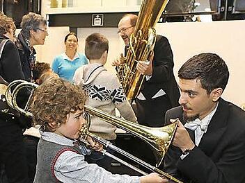 Posaunist Angelos Kritikos lässt in die Posaune blasen, im Hintergrund erklärt Solotubist Heiko Triebener sein Instrument. Foto: Barbara Herbst