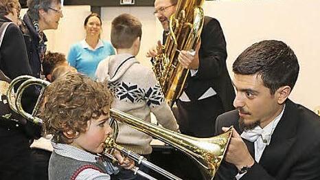 Posaunist Angelos Kritikos lässt in die Posaune blasen, im Hintergrund erklärt Solotubist Heiko Triebener sein Instrument. Foto: Barbara Herbst