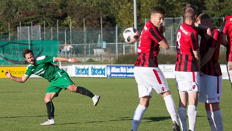 Ein Freisto&szlig; von Lukas Mosert (gr&uuml;nes Trikot) wird von der Memmelsdorfer Mauer abgewehrt.  Foto: Heinrich Wei&szlig;