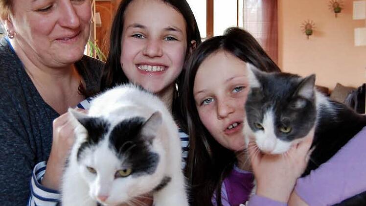 Vermissen ihre Katze Muffin: Melanie Potsch (von links) und ihre Töchter Lina (10, mit Kater Anton) und Rosalie (7, mit Katze Luna). Foto: Sigismund von Dobschütz