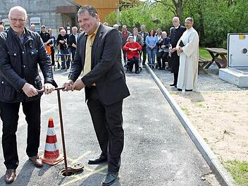 Nochmal zugepackt: Die Bürgermeister Borst und Niediek drehen die Leitung auf, die das Übergabebauwerk (rechts hinten) speist. Foto: Ralf Kestel