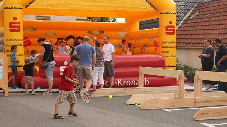 Tennis für Anfänger: Erste Übungen mit Ball und Schläger vor der Hüpfburg neben St. Michael.