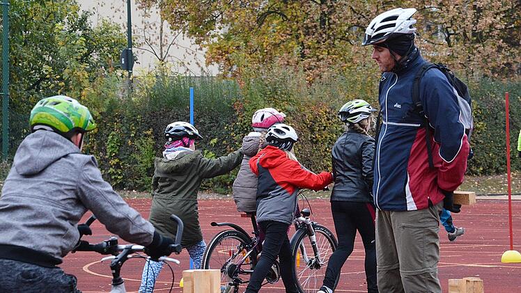 Zahlreiche Übungen standen am Sportplatz des Mehrgenerationenhaus St. Michael am Dienstagvormittag auf dem Programm. Unter anderem musste ein Kind blind auf dem Rad einen Parcour durchfahren. Unterstützung bekam es durch Mitschüler und Lehrkräfte. Foto: Friedrich