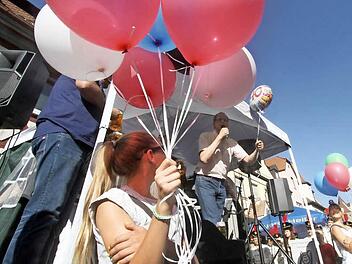 Der Ballon, den German Hacker starten lässt, weist auf das Jubiläumsjahr hin. Die anderen Ballons sind in den Stadtfarben Herzogenaurachs und der Partnerstadt Wolfsberg. Fotos: Michael Busch