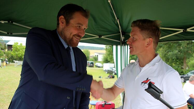 Bürgermeister und Schirmherr Martin Mittag (links) erhielt von Ortssprecher Udo Jahn die nagelneue Dorfchronik als Geschenk. Foto: Bettina Knauth