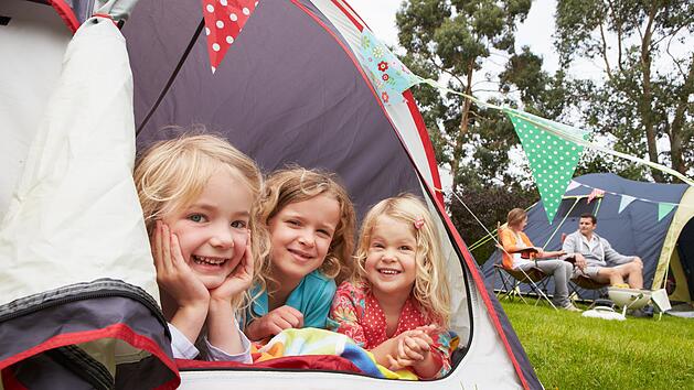 Family Enjoying Camping Holiday On Campsite Familie genießt Campingurlaub auf dem Campingplatz