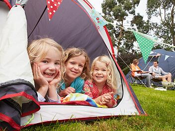 Family Enjoying Camping Holiday On Campsite Familie genießt Campingurlaub auf dem Campingplatz