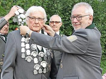 Schützenmeister Manfred Sievers und Alfried Köstner legen dem neuen König die Königskette um. Im Hintergrund Peter Wilhelm, der 2. Ritter.