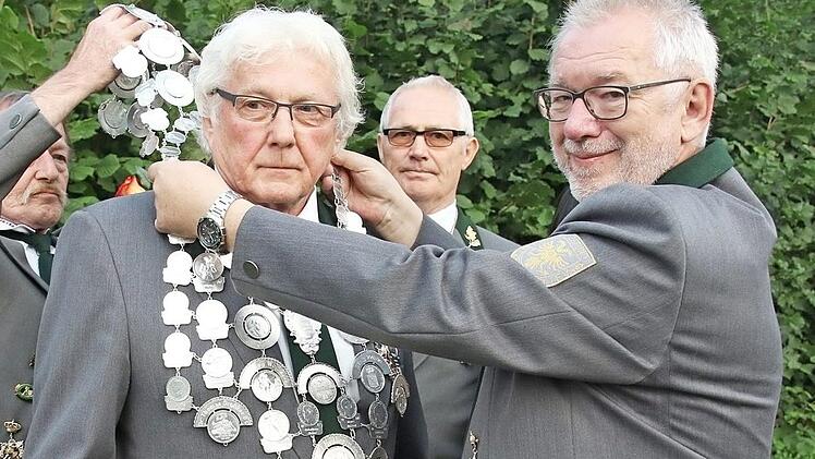 Schützenmeister Manfred Sievers und Alfried Köstner legen dem neuen König die Königskette um. Im Hintergrund Peter Wilhelm, der 2. Ritter.