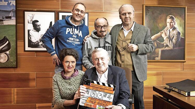 Bei den Dreharbeiten zum ARD-Zweiteiler „Die Dasslers – Pioniere, Brüder und Rivalen“ im Jahr 2017: Treffen mit den Schauspielern in einem im Studio in Prag nachgestellten Büro von Puma-Gründer Rudolf Dassler, der auf dem Foto an der Wand zu sehen ist (hinten von links): Puma-Pressesprecher Ulf Santjer, Helmut Fischer und Rudolf-Dassler-Darsteller Hanno Koffler mit Hannah Herzsprung und Horst Widmann (vorne).