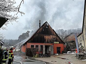 Die Feuerwehr löscht den Brand in der Brauerei neben dem Gasthaus (r.) in Thuisbrunn.